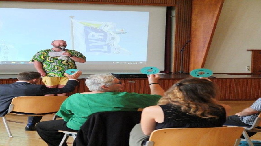 Referent auf der Gender Fachtagung im Gespräch mit den Teilnehmern im Tagungsraum